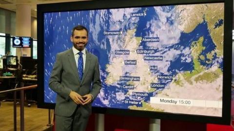 BBC Weather presenter Ben Rich beside map