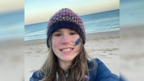 A selfie of Naomi at the beach in cold weather