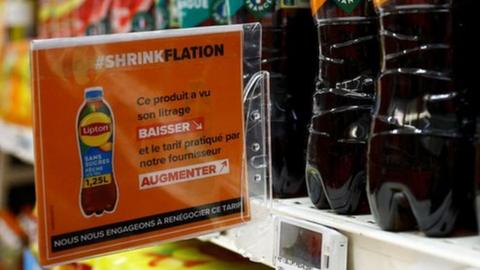 bottles of ice tea and shrinkflation sign