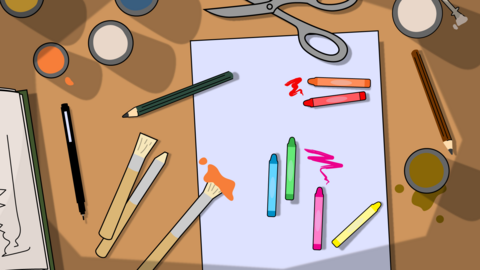 Cartoon top-down view of an art desk with paper, crayons, pencils, brushes, scissors