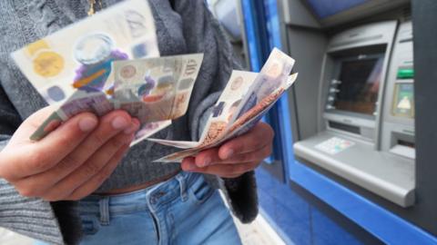 Woman taking money out of cash machine