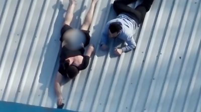 Two men on roof trying to ditch phones