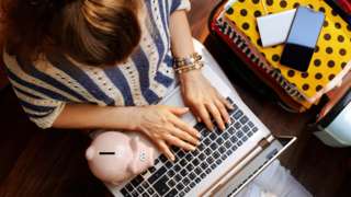Woman with computer and piggy bank