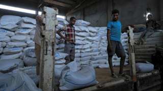 Several men unload food aid in Ethiopia