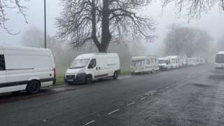 Vans lined up on a road running alongside The Downs in north Bristol