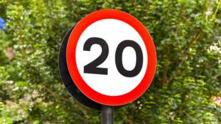 Road sign marking the start of a 20 mph speed limit zone in a residential area