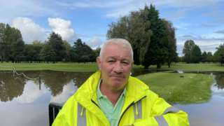 Adrian Jones standing in front of the flooded gold course