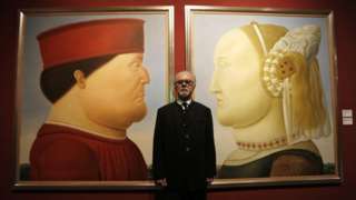 Fernando Botero stands in front of two of his paintings