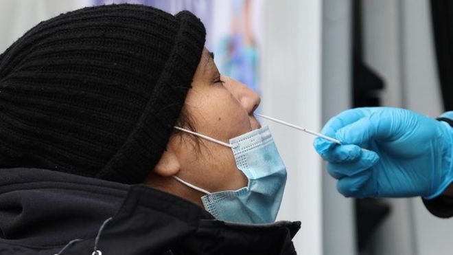 A woman is getting a Covid-19 test at a Covid-19 testing center next to the Queens Hospital Center as hundreds of residents line up to get Covid-19 test in Queens of New York, United States on December 28, 2021