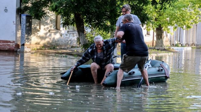 An elderly man is helped to get in an inflatable boat in Kherson, southern Ukraine. Photo: 6 June 2023