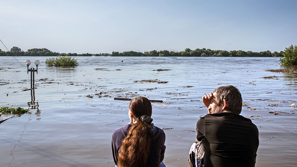 People watch the flood after Nova Kakhovka dam explosion in Kherson, Ukraine on June 7, 2023
