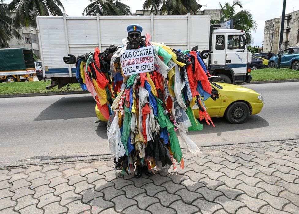 A man posing in the street dressed in plastic waste - 5 June.