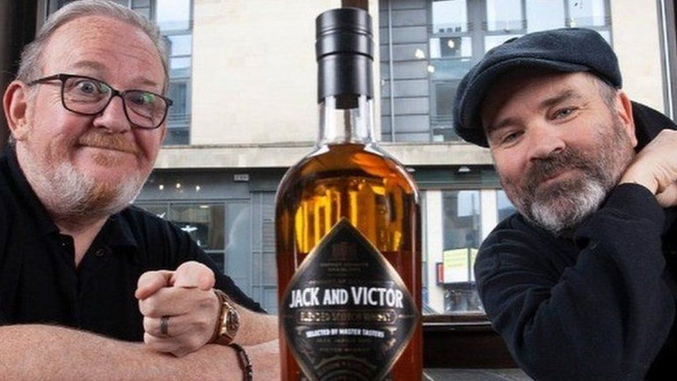 Greg Hemphill and Ford Kiernan with a bottle of Jack and Victor