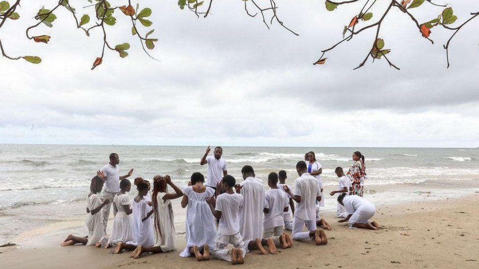 Group of people praying on beach, 9 September