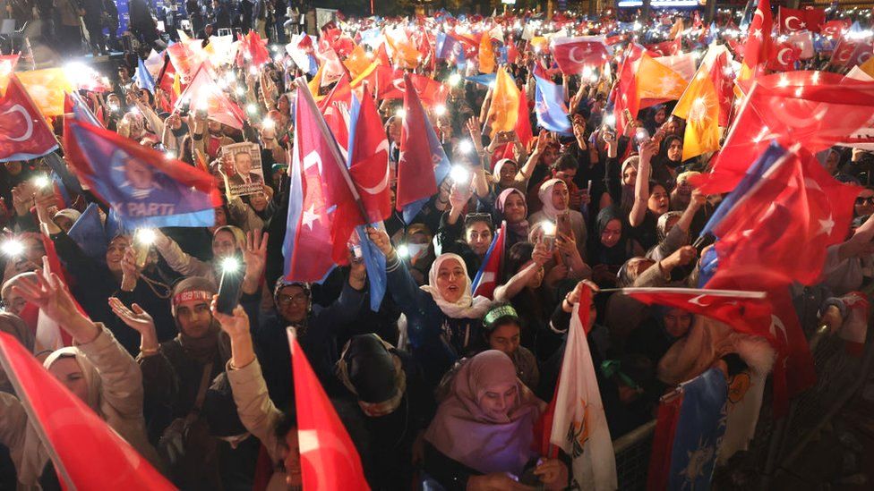 Supporters of Turkish President Tayyip Erdogan wave flags outside the AK Party headquarters after polls closed in Turkey's presidental and parliamentary elections in Ankara Turkey on 15 May