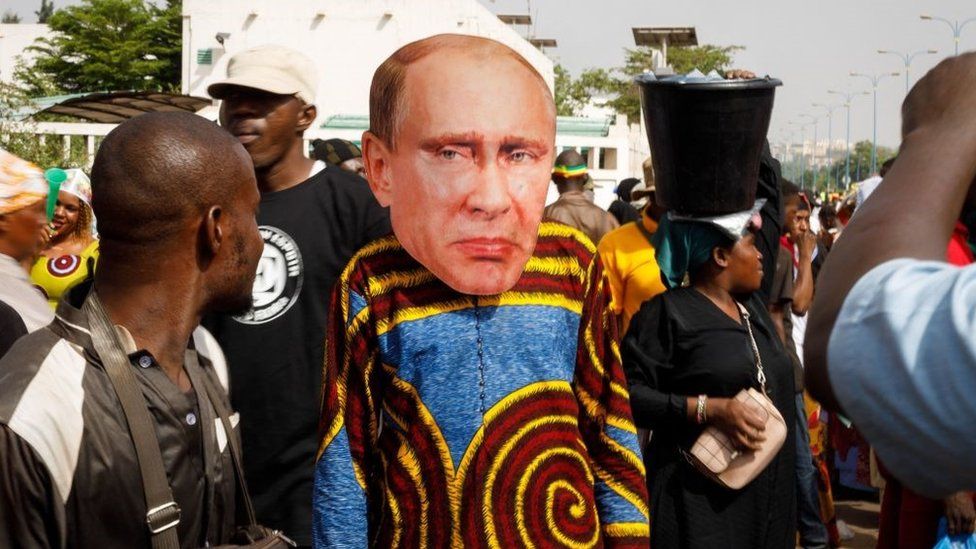 A supporter of Malian Interim President wears a face mask of the President of Russia, Vladimir Putin, during a pro-Junta and pro-Russia rally in Bamako on May 13, 2022