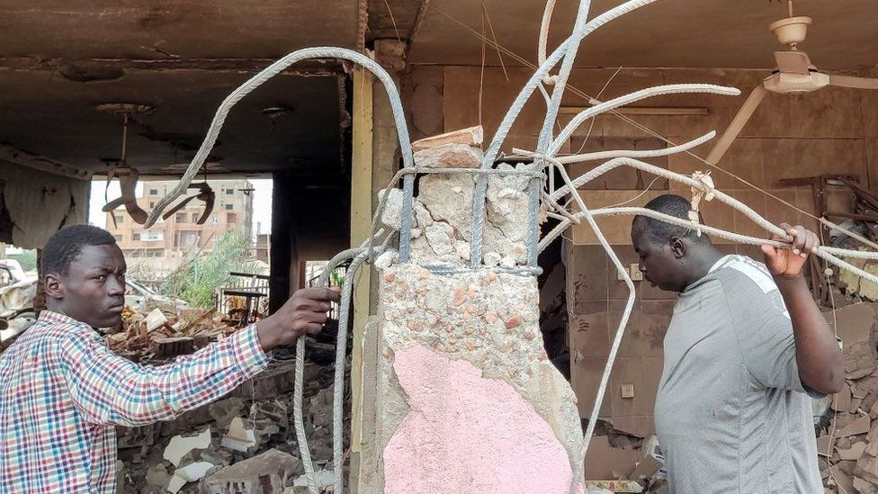 People inspect the rubble at a house that was hit by an artillery shell in the Azhari district in the south of Khartoum on June 6, 2023